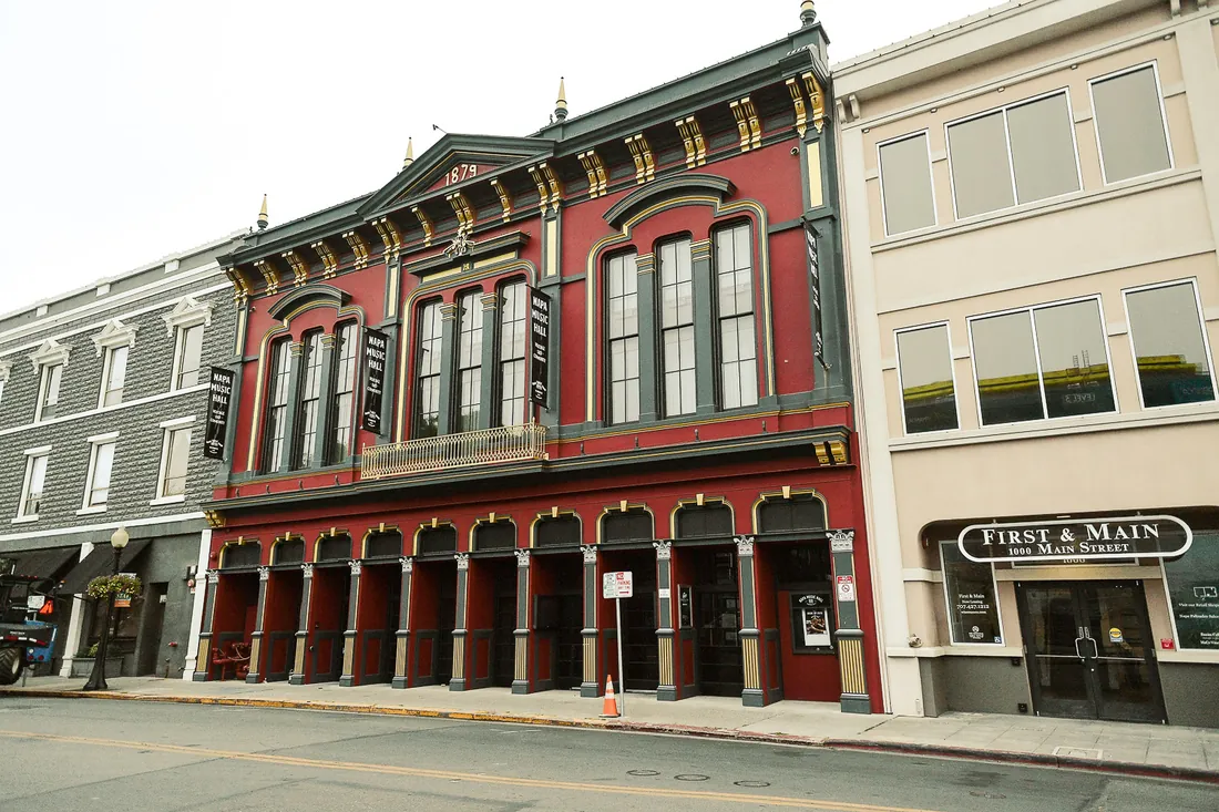 The 1879 Napa Music Hall on Main Street, its arcade of columns running the length of the pavement, with the First & Main building beside it.